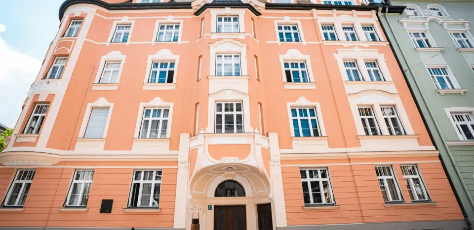 Pfirsichfarbene Straßenfassade des Praxishauses in Schwabing