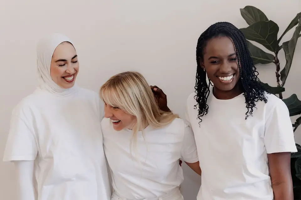 Drei Mitarbeiterinnen des LORA-Teams, die zusammen lachen